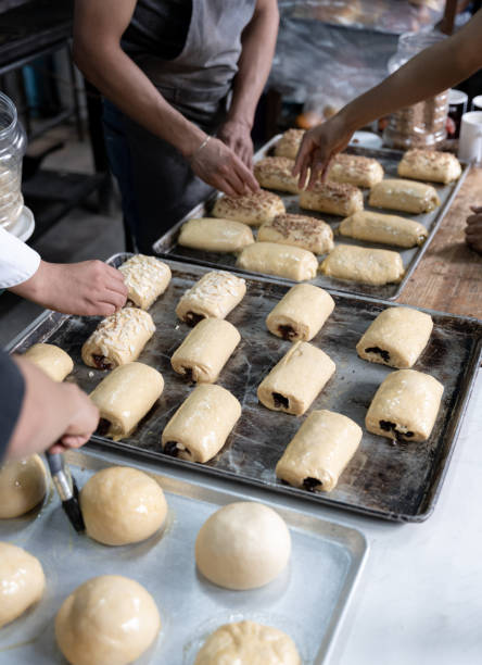istock Four young Hispanic bakers are preparing different sweet buns in a bakery 1496669537