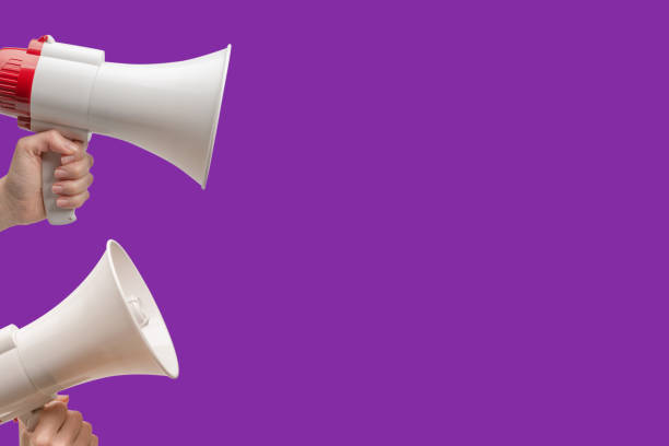 istock Megaphone in woman hands on a purple background. 1496681527