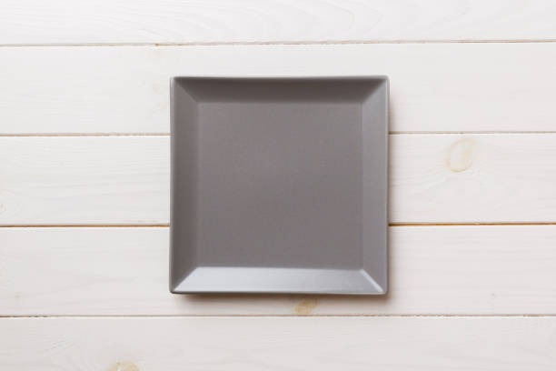 istock Top view of empty square plate on wooden background. Empty space for your design 1496685523