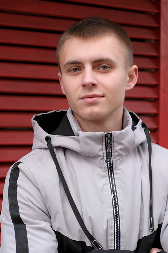 Urban street portrait of a young handsome guy in stylish youth sportswear
