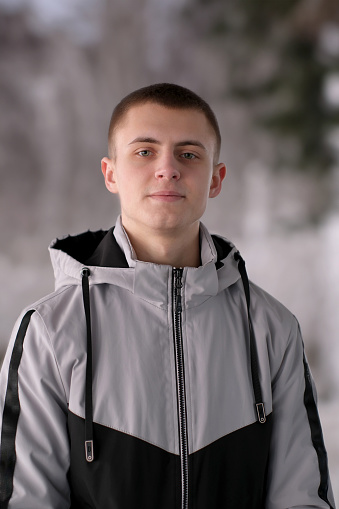 Urban street portrait of a young handsome guy in stylish youth sportswear