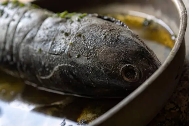 A video clip showing the seasoning and preparation of tonnarella fish for cooking.