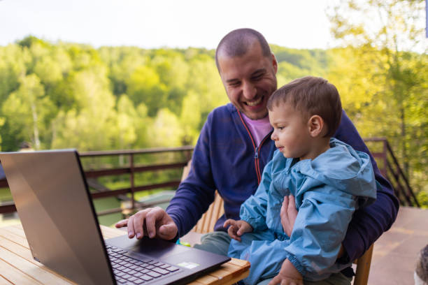 istock Guiding Son through Laptop Activities 1496689428