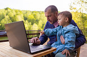 Father Assisting Son on a Laptop
