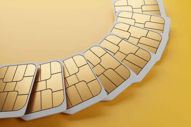 Unbranded white nano 5G smartphone SIM cards arranged in a fan shape on yellow background. Illustration of the concept of untraceable anonymous SIM cards , prepaid SIM cards and telecommunication