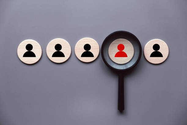 istock Human resources and management concept. Magnifying glass over a red candidate people icon. 1496692745