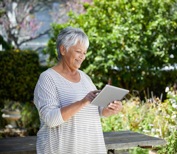 istock Beautiful senior woman using her digital tablet 1496692818