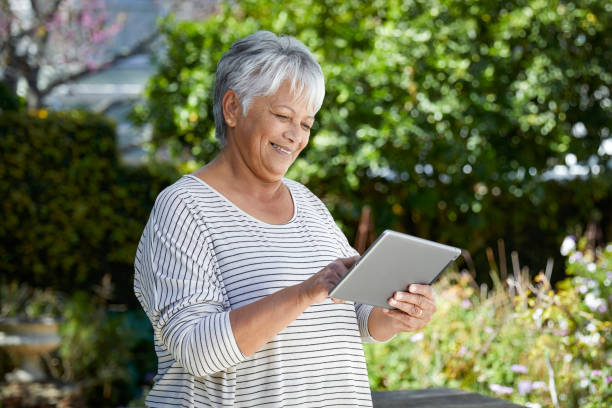 istock Beautiful senior woman using her digital tablet 1496692824