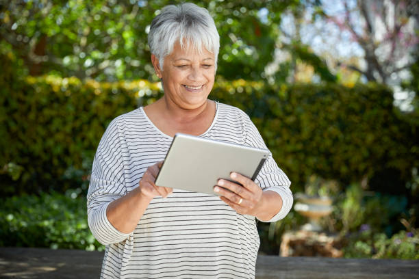 istock Beautiful senior woman using her digital tablet 1496692898