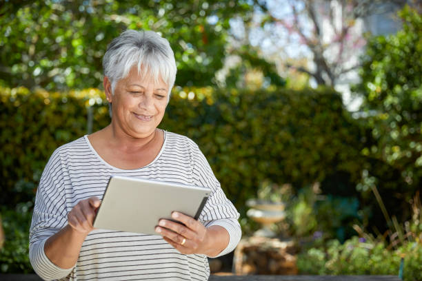 istock Beautiful senior woman using her digital tablet 1496692916