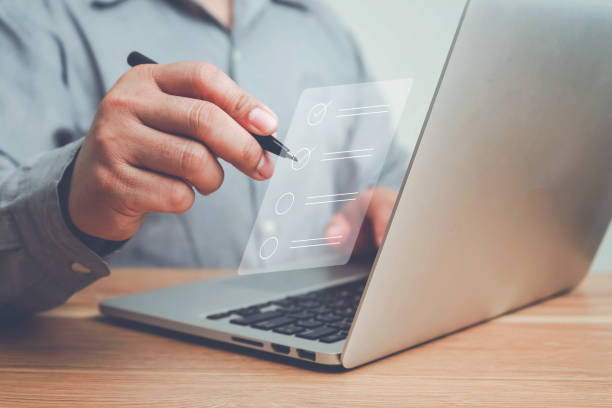 istock Business performance checklist, Quick checklist and clipboard management concept, job applicants, businessman using laptop doing online checklist survey,Employees must complete the online survey form. 1496695183