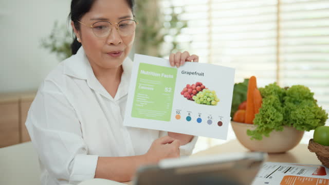 Asian mature adult woman is giving a presentation online the nutrition of vegetables and fruits to audiences.