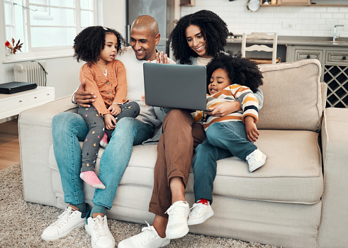 Happy, relax and family with a laptop for a movie, comedy show or subscription service. Smile, together and parents with children on the sofa for a film, series or entertainment on a computer