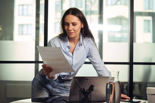 istock Concentrated young female employee dealing with business documentation in office 1496700793