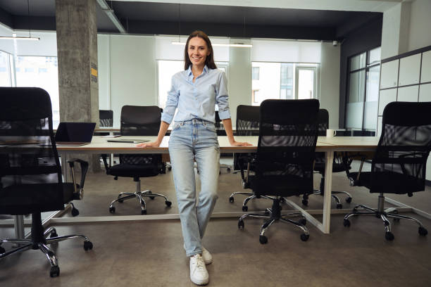 istock Happy company employee posing for camera in modern workplace 1496700914
