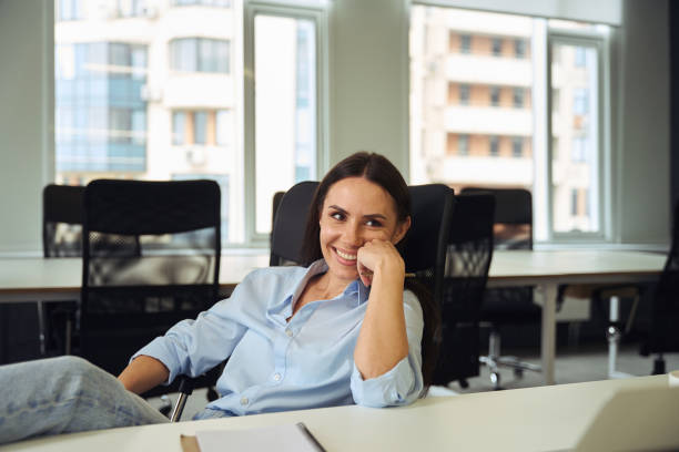 istock Joyful female employee seated in her workplace in morning 1496700921