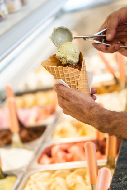 istock Close-up of a man preparing a multi flavored ice cream cone 1496701918