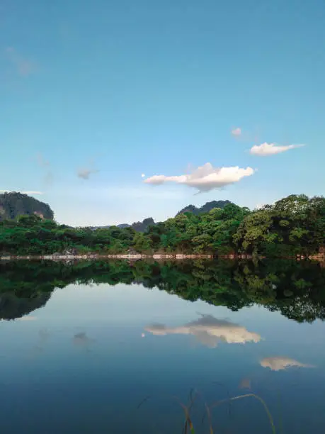 Photo of An amazing view of an artificial lake in an abandoned marble factory with a beautiful reflection. It is located in Maros, South Sulawesi, Indonesia.