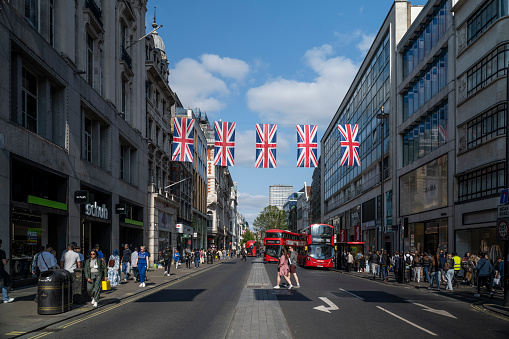 Quiet day on Oxford Street with tourists and pedestrians on a sunny spring day.