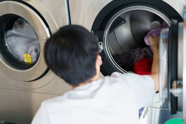 istock Man washing clothes at vendor washing machine. 1496714809