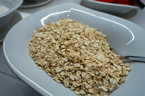 Close-up of a small glass bowl filled with rolled oats.