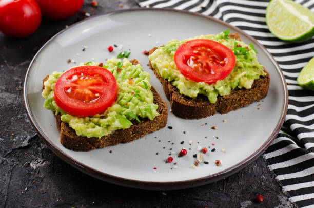 istock Avocado Toasts with Tomato, Healthy Snack or Breakfast on Dark Background 1496716485
