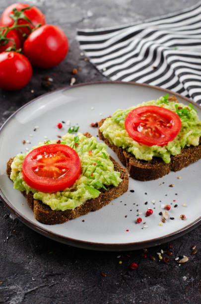 istock Avocado Toasts with Tomato, Healthy Snack or Breakfast on Dark Background 1496716503