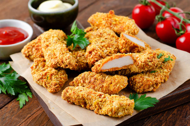 istock Delicious Crispy Fried Breaded Chicken Breast Strips with Ketchup on Dark Background 1496716530
