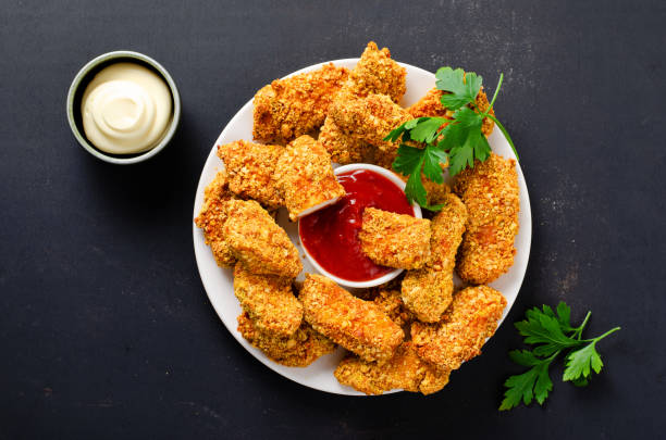 istock Delicious Crispy Fried Breaded Chicken Breast Strips with Ketchup on Dark Background 1496716896