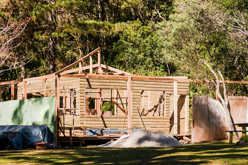 Photo of a log cabin in construction in a nature place