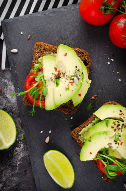 istock Avocado Toasts with Tomato, Healthy Snack or Breakfast on Dark Background 1496718056