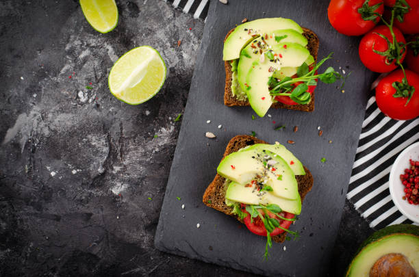 istock Avocado Toasts with Tomato, Healthy Snack or Breakfast on Dark Background 1496718921