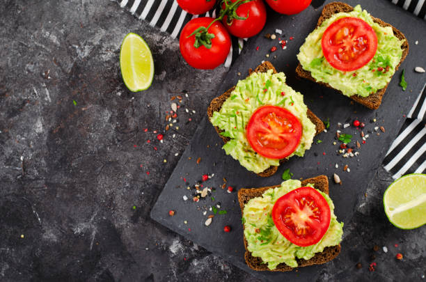 istock Avocado Toasts with Tomato, Healthy Snack or Breakfast on Dark Background 1496718956