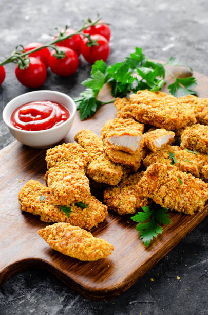 istock Delicious Crispy Fried Breaded Chicken Breast Strips with Ketchup on Dark Background 1496719045