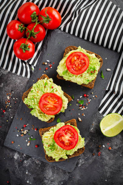 istock Avocado Toasts with Tomato, Healthy Snack or Breakfast on Dark Background 1496719081