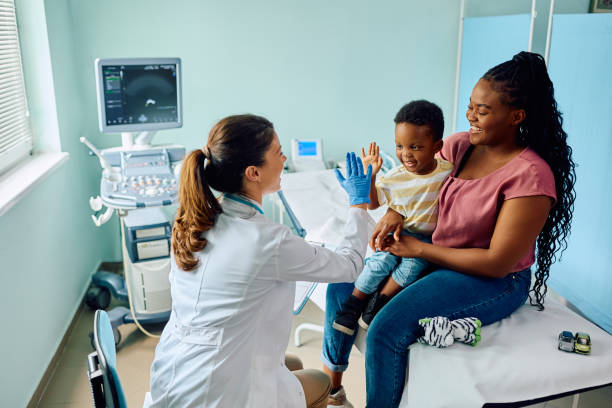 High-five for being such a brave little boy! Happy African American boy giving high five to his pediatrician after medical examination at doctor's office. paediatrician stock pictures, royalty-free photos & images