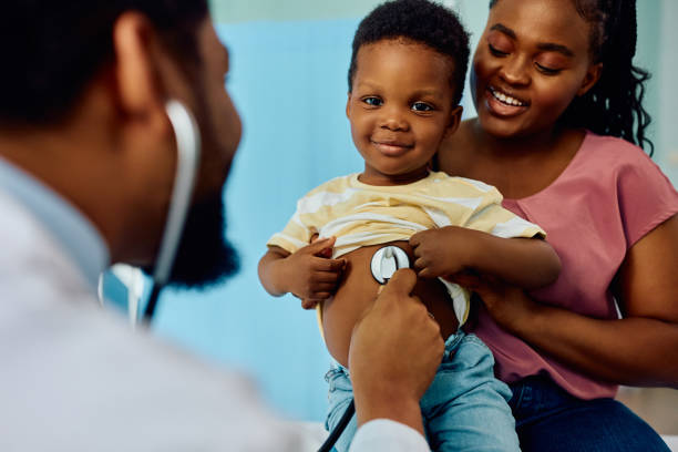 istock Smiling black boy during medical checkup at pediatrician's looking at camera. 1496720438