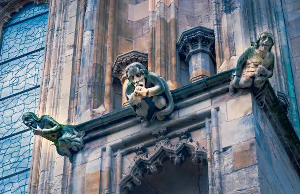 Three humanoid gargoyles stare down at passers by and worshipers from the ancient stone walls of Yorkminster, Cathedral, York