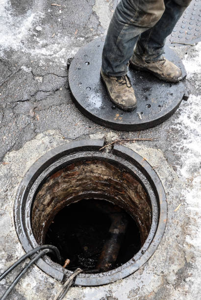 istock Urban road under construction, asphalting in progress, workers near sewer manhole, feet fragment 1496720717
