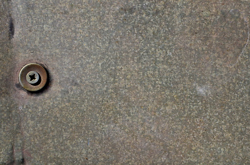 Metal ornaments and hinges on two brown wooden church doors.