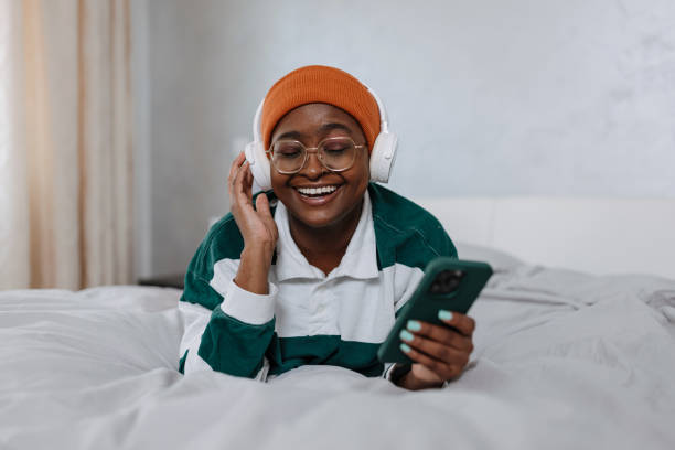 istock Smiling woman listens musing on her mobile phone 1496721898