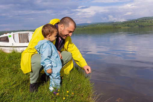 Nature becomes their playground as a father and son walk by the lake, embracing the serenity and embracing each other's company.