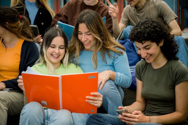 istock Cheerful groupmates studying together on street 1496723299
