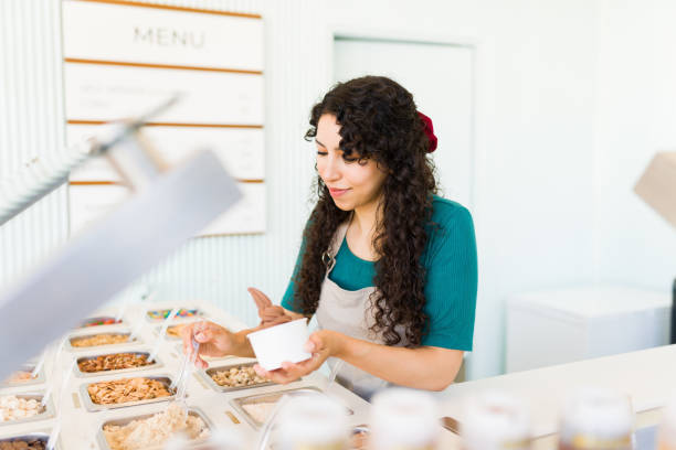 istock Busy young woman working serving toppings on chocolate ice cream 1496724057