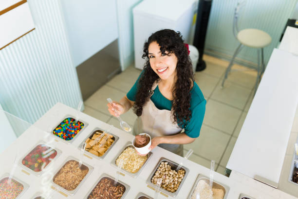 istock High angle of a happy worker serving ice cream with toppings 1496724169