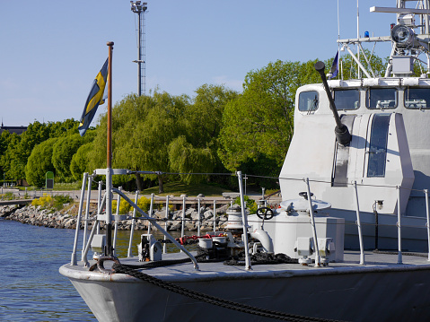 an older naval warship in the harbor during the summer