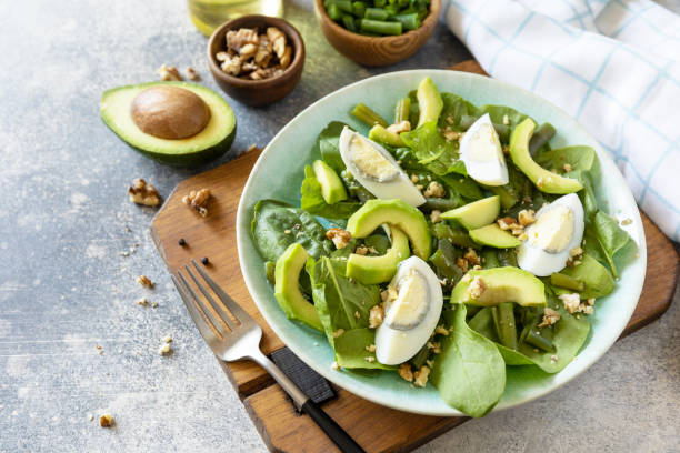 istock Organic green avocado and spinach salad with eggs, green beans, nuts on a stone table. Healthy food, summer healthy eating. Copy space. 1496728302