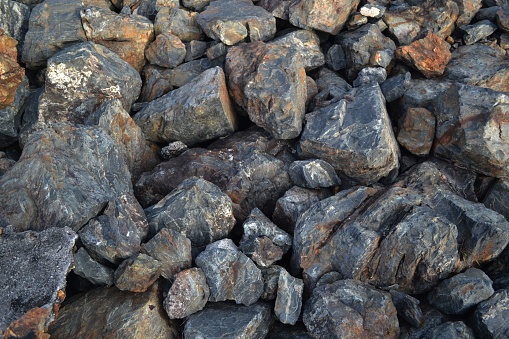 This image features a rocky landscape covered in small black rocks