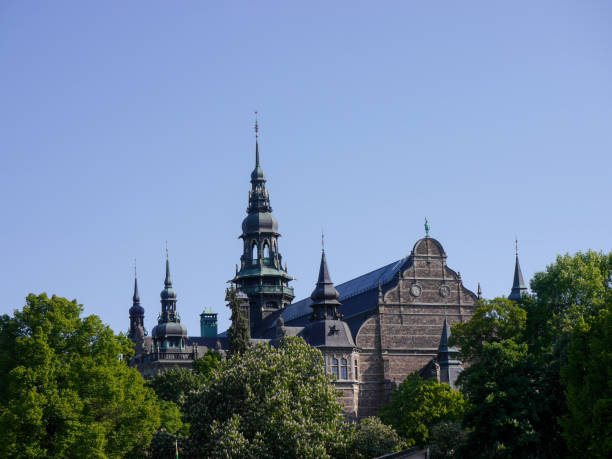 istock Low angle view of building and trees against clear blue sky 1496730707