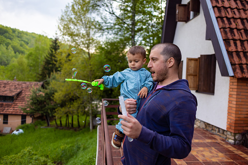 Father and son share a special connection as they create bubbles in nature.